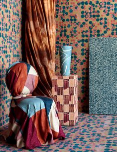 a room with colorful wallpaper and a blue vase on the floor next to it