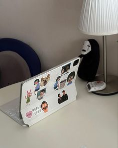 an ipad case with stickers on it sitting on a desk next to a lamp