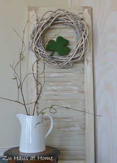 a white pitcher sitting on top of a table next to a bird's nest