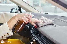 a woman is cleaning the dashboard of her car with a micro towel and mitt