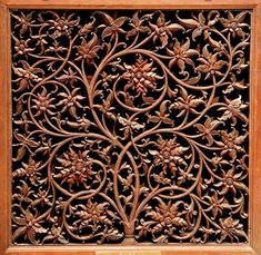 an intricately carved wooden panel with flowers and leaves