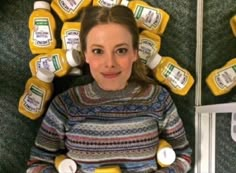 a woman is surrounded by mustards and ketchup bottles