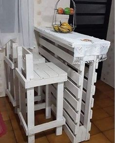 a table made out of pallets with two stools