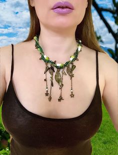 This Amazing Twisted  Woodland Necklace  with Charms nature  inspired. Perfect Necklace for Renaissance Festival  Celtic wedding or  everyday wear. Handmade item  Materials: Pendant  Leaf charms different sizes, Crystal rondelle and bicone beads, Mushroom beads, antique bronze  chain,  pinecones  Item details Materials: antique bronze findings, Crystal Bicone, Green Rondelle Beads ,Curb Chain , Leaf Pendant, green mushrooms beads , spike beads Czech glass, and other charms  Style: Celtic, Bohemi Beads Mushroom, Mushroom Beads, Twisted Necklace, Pinecone Necklace, Fairy Cosplay, Celtic Wedding, Woodland Fairy, Leaf Charms, Leaf Pendant