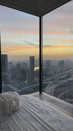 a bedroom with a large window overlooking the city