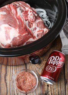 an image of meat in the crock pot with onion rings and seasoning next to it