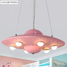 a pink ceiling light hanging over a child's room