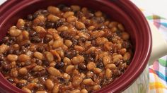 a red bowl filled with beans on top of a table