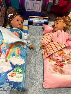 two dolls laying next to each other on the floor