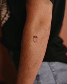 a person with a small tattoo on their left arm and the other arm behind him