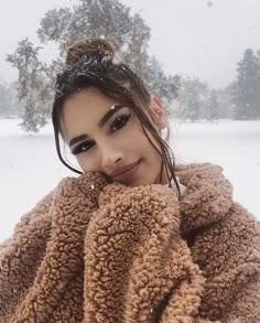 a young woman is posing in the snow