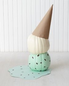 a green and white pumpkin with a cone on top