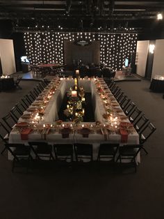 a long table is set up with candles and place settings for an event or party