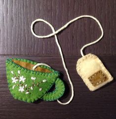 two small pieces of felt sitting on top of a wooden table next to a string