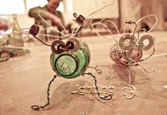 two glass bugs sitting on top of a table next to each other with the word love spelled in front of them