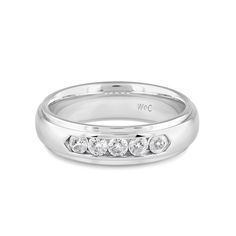 A dashing ring for a debonair gentleman. This band beautifully reflects your man's sophisticated style. The polished ring features a domed profile with a flat edge. It is punctuated by five diamonds on a secure channel setting for an extra brilliant shine. Silver Diamond Channel Set Eternity Band, Luxury Channel-set Eternity Band In Fine Jewelry Style, Luxe Necklace, Wedding Halo, Channel Set, Gorgeous Engagement Ring, Ring Size Guide, Earrings Collection, Sophisticated Style