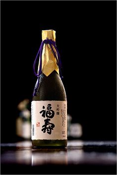 a bottle of sake on a table with other bottles in the backgroung