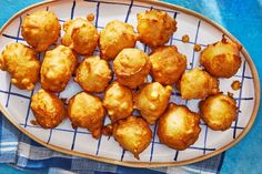 some fried food on a white plate with blue and white checkered table cloth next to it