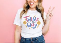 a woman wearing a t - shirt that says twins on the way