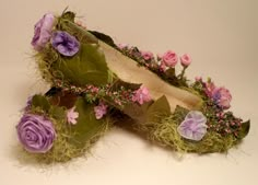 a pair of shoes covered in flowers and moss