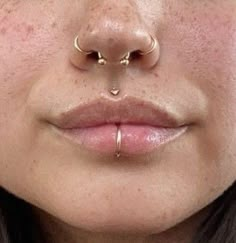 a woman's nose with two piercings on her nose and one in the middle