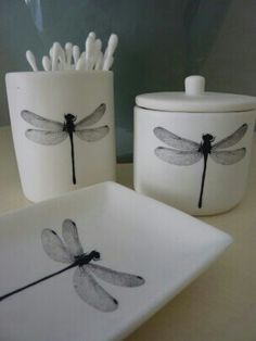 three dragonflies on white dishes with black handles