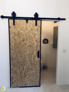 an open glass door in a room with white walls and black metal bars on the doors