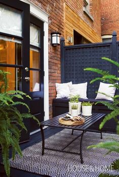 a black and white patio with plants on the table, potted plants in front of the door