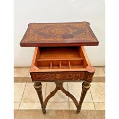 an old wooden desk with drawers and writing on the top, sitting on tile flooring