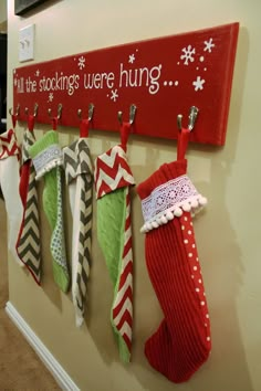 stockings are hung up on the wall in front of a sign that says fill the stockings were hung