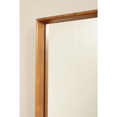 a wooden frame mirror hanging on the wall