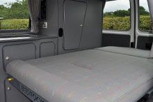 the interior of a van with an extra bed