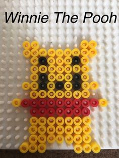 a close up of an object made out of plastic beads with the words winnie the pooh on it