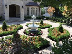 a garden with flowers and a fountain in the middle