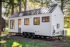 a tiny house is parked in the woods