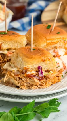 two pulled pork sandwiches on a plate with toothpicks