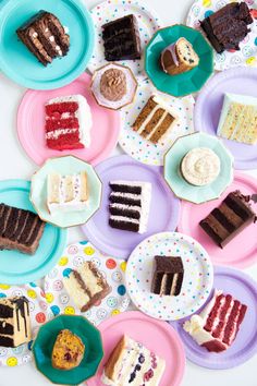 a table topped with plates filled with different types of cakes and desserts on paper plates