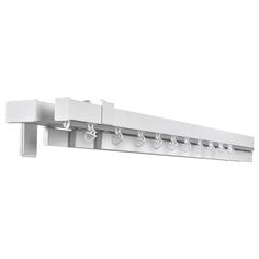 a white wall mounted shelf with hooks on it's sides and four lights hanging from the ceiling