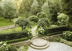 an aerial view of a garden with stone steps and plants in the center, surrounded by greenery