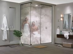 a man and woman are in the shower with their reflection on the glass door as they look at each other