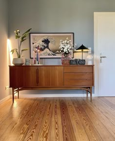 a living room with wood floors and a painting on the wall