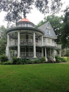 a large white house sitting on top of a lush green field