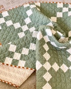 a green and white quilt on the ground