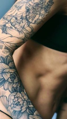 a woman's arm with flowers on it, and the bottom half of her body