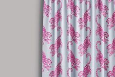 a pink and white curtain hanging on the side of a window