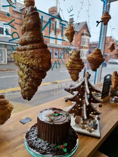 a table topped with lots of cakes and pastries next to a window covered in icing