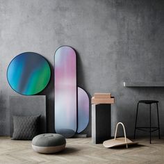 an assortment of modern furniture in a room with concrete walls and flooring, including stools