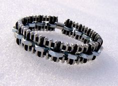 two black and silver bracelets sitting in the snow