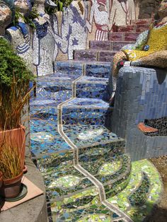 there are many steps made out of glass tiles on the street and plants in pots