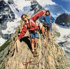 two men climbing up the side of a mountain